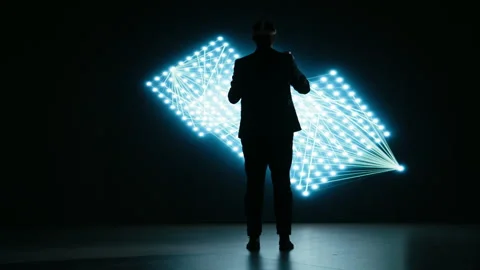Engineer wearing VR headset gear to look at glowing AI neural network Stock Footage 329945205