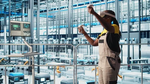 Engineer wearing VR headset in smart factory looking at data to do optimizations Stock Footage 305514646