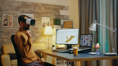 Engineer wearing a VR headset working in virtual space designing a new motor Stock Footage 125849459