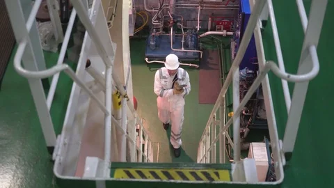 Engineer wearing white suit with grey stripes walks upstairs Stock Footage 117588746