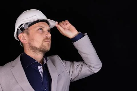 Engineer with white hard hat standing confidently isolated on black backgroun Fotos de archivo
