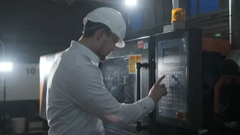 Engineer in a white helmet and white clothes working on the machine at the Video stock 114504546