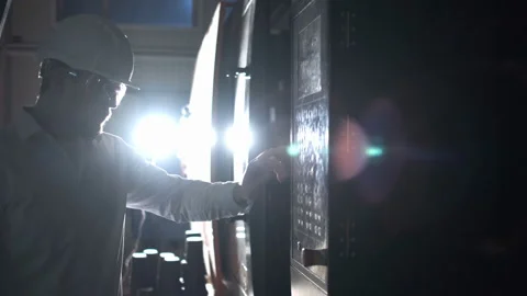 Engineer in white helmet and white clothes includes the machine in the factory Video stock 114505792