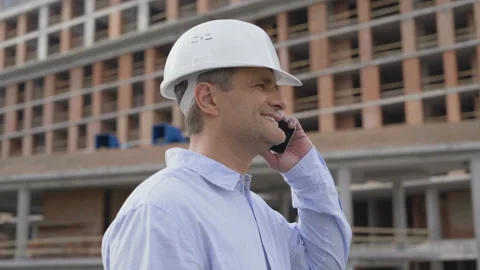 Engineer with white helmet calling by phone. 4 K Stock Footage 111771204