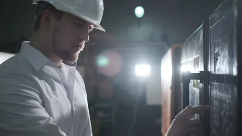 Engineer in a white helmet checks the condition of the Metalworking machine Stock Footage 107413387