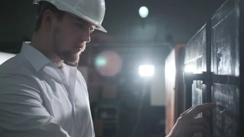 Engineer in a white helmet checks the condition of the Metalworking machine Stock Footage 114504798