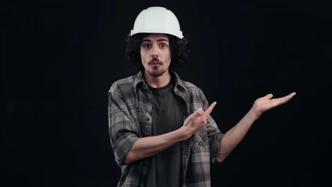 The engineer with the white helmet points with his index finger to one side and Stock-Footage 156277640