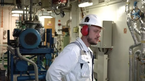 Engineer in a white overalls and helmet crosses his arms over his chest. Stock Footage 120415680