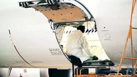 An engineer in a white robe checks the state of the internal fuselage for Stock Footage 102617678