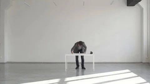 Engineer in a white room with an eraser erases a drawing or sketch on paper Stock Footage 124941330