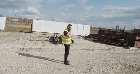 An engineer who walks the construction site and checks the plan. Stock Footage 127056797