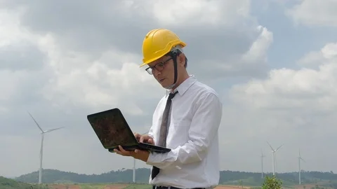 Engineer at windmill power plant with notebook computer in hand. Slow motion Stock Footage 116489542