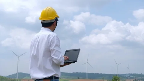 Engineer at windmill power plant with notebook computer in hand. Slow motion Stock Footage 116553357