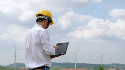 Engineer at windmill power plant with notebook computer in hand Stock Footage 116553633