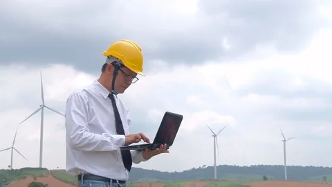 Engineer at windmill power plant with notebook computer in hand. Slow motion Stock Footage 116976852