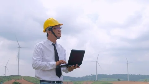 Engineer at windmill power plant with notebook computer in hand Stock Footage 117504353