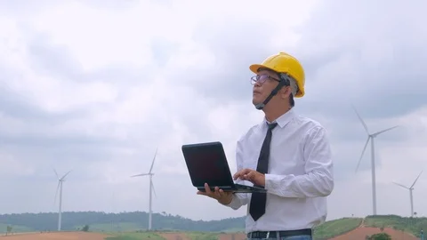 Engineer at windmill power plant with notebook computer in hand Stock Footage 117506495