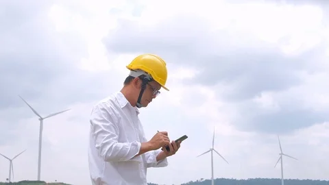 Engineer at windmill power plant with smartphone in hand. Slow motion Stock Footage 117500104