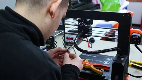 Engineer Wiring A 3D Printer In A Workshop. Stock Footage 100756987