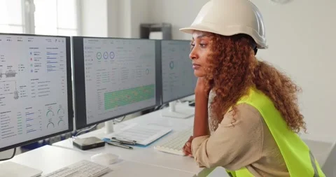 Engineer woman in hardhat analyzing industrial dashboards on computer monitors Stock Footage 342168328