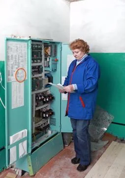 Engineer  woman in machine room (elevator) . Stock Photos