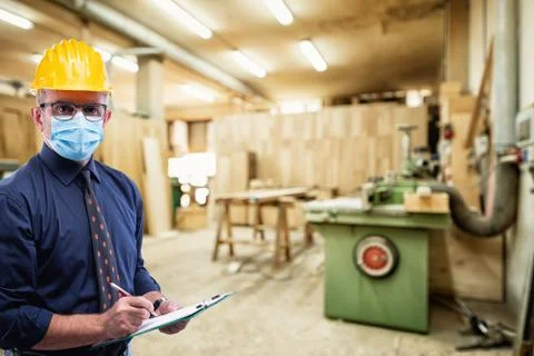 Engineer at work protects the face with the surgical mask. Construction indus Stock Photos