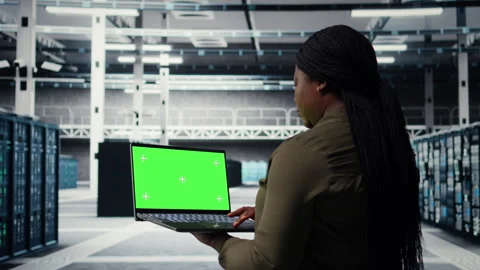 Engineer at work using green screen laptop in data center to check hardware Stock Footage 317203456