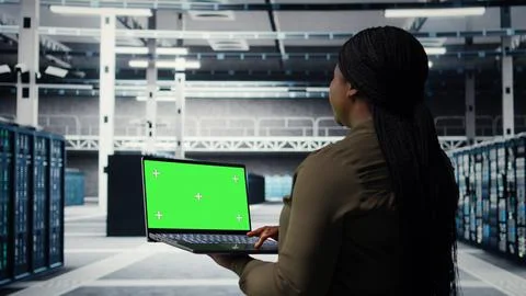 Engineer at work using green screen laptop in data center to check hardware Stock Photos