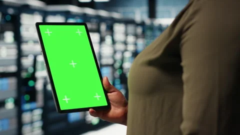 Engineer at work using isolated screen tablet in data center to check hardware Stock Footage 317124551