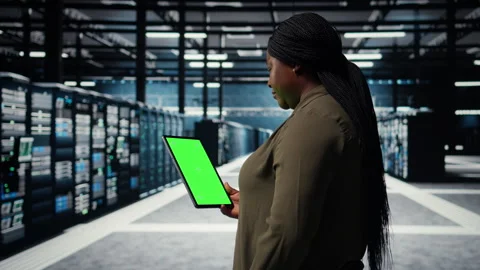 Engineer at work using isolated screen tablet in data center to check hardware Stock Footage 317125256