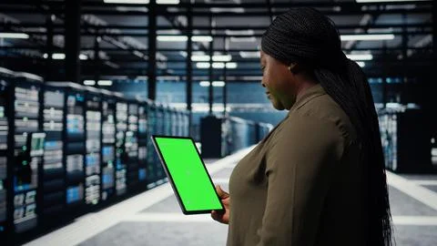 Engineer at work using isolated screen tablet in data center to check hardware Stockfoto's