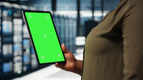 Engineer at work using isolated screen tablet in data center to check hardware Stockfoto's