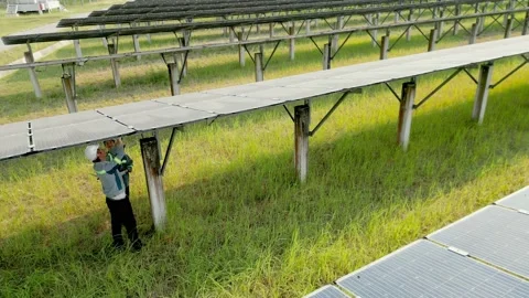 Engineer worker checking a Solar Panels and walking in solar farm. Stock Footage 238579315