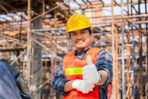 Engineer / worker man hand giving thumb up over blurred construction site Stockfoto's