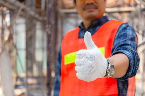 Engineer / worker man hand giving thumb up over blurred construction site 스톡 사진