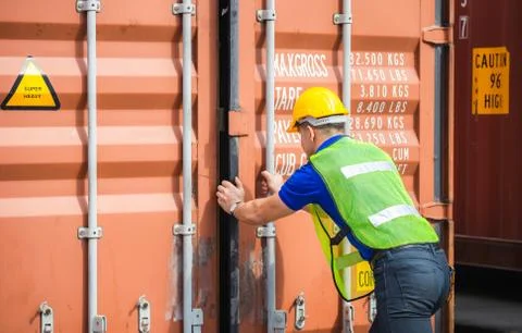 Engineer worker man in hardhat and safety vest checking containers box Stockfoto's