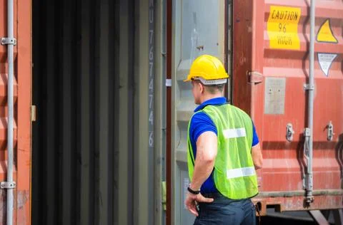 Engineer worker man in hardhat and safety vest checking containers box from c Stockfoto's