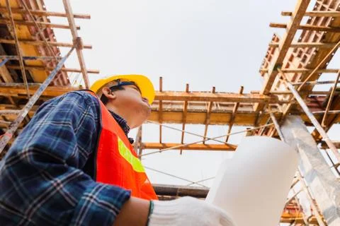 Engineer / worker man holding blueprint checking and planning project at site Foto stock