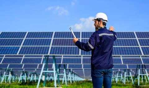 Engineer worker portrait with solar panel at solar farm Stock Photos
