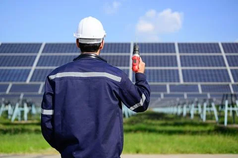 Engineer worker portrait with solar panel at solar farm Stock Photos