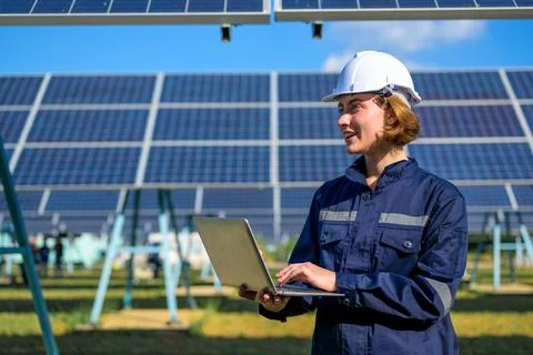 Engineer worker portrait with solar panel at solar farm Stock Photos