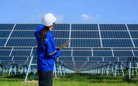 Engineer worker portrait with solar panel at solar farm Stock Photos