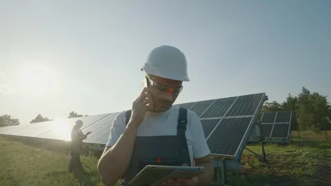 Engineer worker talking about mobile phone solar power distribution panels. Stock Footage 257752184