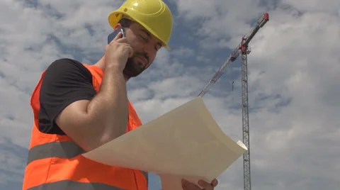 Engineer worker talking smart phone while readying construction plan crane view Stock Footage 39612838