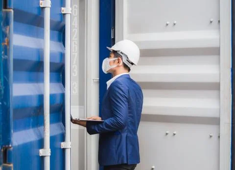 Engineer worker wearing protection face mask checking containers box from cargo Stockfoto's