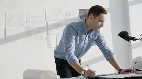 Engineer working in a bright office, standing in front of the table. Video stock 256693794