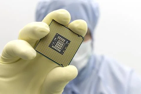 An engineer working in a clear room wearing a special uniform and protective Stock Photos