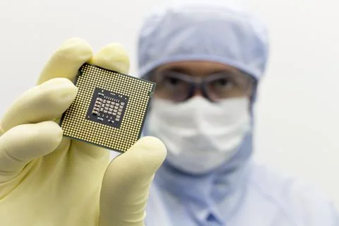An engineer working in a clear room wearing a special uniform and protective Stock Photos