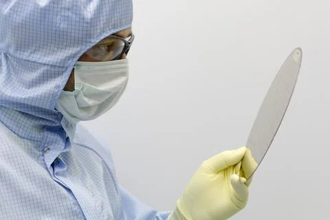 An engineer working in a clear room wearing a special uniform and protective Foto stock