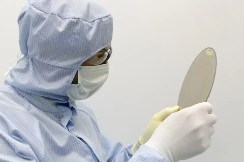 An engineer working in a clear room wearing a special uniform and protective Foto stock